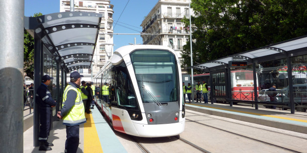 Algerian workers look at the tramway arriving at a tram stop on May 1, 2013 during the inauguration of the first section of the tramway of Oran, Algeria. The tramway is part of a national project to create a rail transport network, that has started in Algiers and is expected to continue in several Algerian cities. AFP PHOTO AMAL BELALLOUFI (Photo credit should read AMAL BELALLOUFI/AFP/Getty Images)