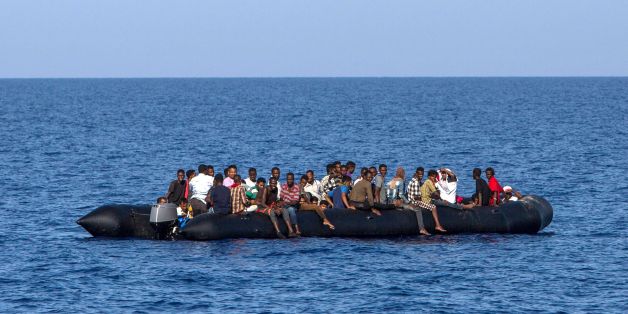TOPSHOT - Migrants wait to be rescued by Italian coast guard in the Mediterranean Sea, 30 nautic miles from the Libyan coast, on August 6, 2017. / AFP PHOTO / ANGELOS TZORTZINIS (Photo credit should read ANGELOS TZORTZINIS/AFP/Getty Images)