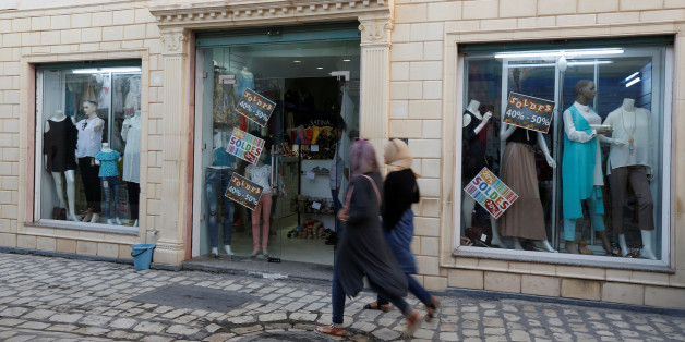 Women look at sale signs placed on a shop's windows while walking through central Mehdia,Tunisia, August 17, 2017. REUTERS/Zoubeir Souissi