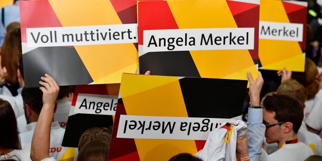 Supporters of the Christian Democratic Union (CDU) react with banners as exit poll results were broadcasted on public television at an election night event at the party's headquarters in Berlin during the general election on September 24, 2017.Germany voted in a general election expected to hand Chancellor Angela Merkel a fourth term, while the hard-right Alternative for Germany (AfD) party is predicted to win its first seats in the national parliament. / AFP PHOTO / Tobias SCHWARZ (Photo
