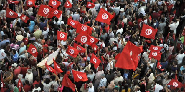 Tunisian demonstrators wave their national flag and shout slogans during a protest against the country's Islamist-led government in front of the Constituent Assembly headquarters in Tunis on August 13, 2013, which marks national women's day, as the president proposed a national unity cabinet to end a protracted crisis. The government, led by the Islamist Ennahda party, and its detractors have been locked in a bitter feud sparked by the July assassination of an opposition politician, the second such killing this year. AFP PHOTO / FETHI BELAID (Photo credit should read FETHI BELAID/AFP/Getty Images)