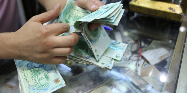A shopkeeper counts money in of his shop at a bazar in Tunis, Tunisia August 10, 2016. REUTERS/Zoubeir Souissi