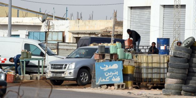 Tunisian smugglers unload barrels of oil, that they illegally imported from Libya to Tunisia, before selling them on a road on February 6, 2016 in Ben Guerdane, some 40 kilometres west of the Libyan border. / AFP / FETHI BELAID (Photo credit should read FETHI BELAID/AFP/Getty Images)