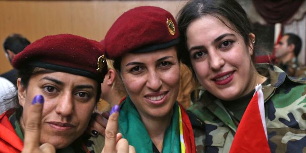 Female members of a Kurdish Peshmerga battalion show their ink-stained fingers after casting their vote in the Kurdish independence referendum in Arbil, on September 25, 2017. Iraqi Kurds voted in an independence referendum in defiance of Baghdad which has warned of 'measures' to defend Iraq's unity and threatened to deprive their region of lifeline oil revenues. / AFP PHOTO / SAFIN HAMED (Photo credit should read SAFIN HAMED/AFP/Getty Images)