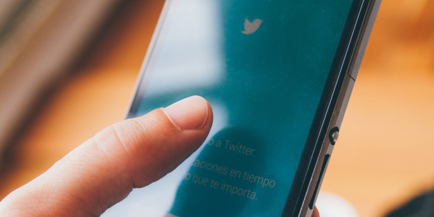 Buenos Aires, Argentina - May 7, 2016: A person tries to enter his Twitter account from his smart phone in the office