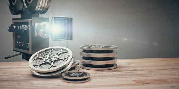 Vintage old movie camera and film cartridge on a wooden table