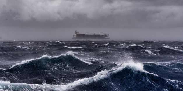 A cargo ship sails on the Mediterranean sea during a thunderstorm some 20 naughtical miles from Malta on September 24, 2017. / AFP PHOTO / ARIS MESSINIS (Photo credit should read ARIS MESSINIS/AFP/Getty Images)