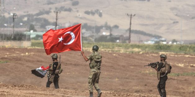 Soldiers holding Turkish and Iraqi flags walk during a joint military exercise near the Turkish-Iraqi border in Sirnak in Silopi district on September 26, 2017.
Turkey launched a military drill with tanks close to the Iraqi border the army said, a week before Iraq's Kurdish region will hold an independence referendum on September 25. / AFP PHOTO / ILYAS AKENGIN (Photo credit should read ILYAS AKENGIN/AFP/Getty Images)