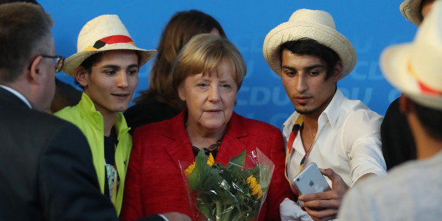 SCHWERIN, GERMANY - SEPTEMBER 19: German Chancellor and Christian Democrat (CDU) Angela Merkel poses for a photo with Syrian refugees after she spoke at an election campaign stop on September 19, 2017 in Schwerin, Germany. Merkel is seeking a fourth term in German federal elections scheduled for September 24 and currently has a double-digit lead over her main rival, German Social Democrat (SPD) Martin Schulz. (Photo by Sean Gallup/Getty Images)