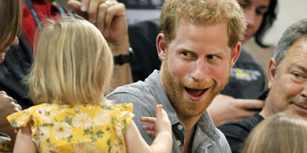 Britain's Prince Harry, patron of the Invictus Games Foundation, shares popcorn with a child while attending the Sitting Volleyball competition at the games in Toronto, Ontario, Canada, September 27, 2017. REUTERS/Fred Thornhill