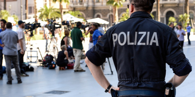 A policeman looks medias in front of the Cassation building, during the supreme court session to decide whether to confirm a one-year prison sentence and a five-year ban from politics in a long-running tax fraud case involving former Italian Prime Minister Silvio Berlusconi's media business interests, on July 31, 2013 in Rome. The final appeal hearing began on Tuesday but one of Berlusconi's lawyers told reporters that the verdict may come only on Wednesday or Thursday. AFP PHOTO / ANDREAS SOLARO (Photo credit should read ANDREAS SOLARO/AFP/Getty Images)