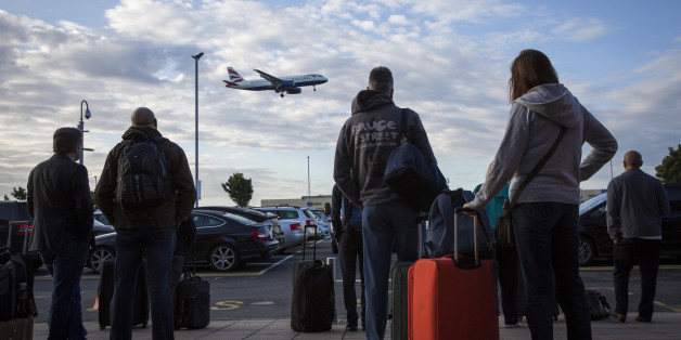 Travellers with their suitcases wait outside the Heathrow Premier Inn for the terminal shuttle bus to take them to their required terminal at Heathrow airport. (photo by Andrew Aitchison / In pictures via Getty Images)
