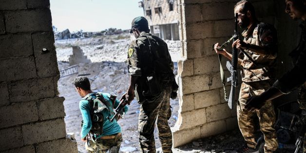 Members of the Syrian Democratic Forces hold a position as they advance to take the central hospital of Raqa on the weastern frontline of the city on September 28, 2017. Syrian fighters backed by US special forces are battling to clear the last remaining Islamic State group jihadists holed up in their crumbling stronghold of Raqa. / AFP PHOTO / BULENT KILIC (Photo credit should read BULENT KILIC/AFP/Getty Images)