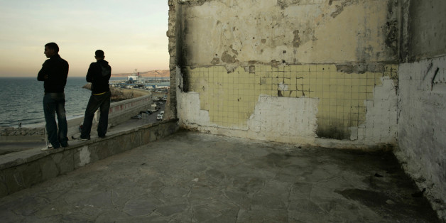 Homeless boys look out at the Strait of Gibraltar near the port in Tangier October 10, 2009. More than 10,000 homeless minors live on the streets of Morocco, according to the Al Jaima association, an association that works with street kids. Most of them are victims of the drugs and the prostitution. REUTERS/Rafael Marchante (MOROCCO SOCIETY)