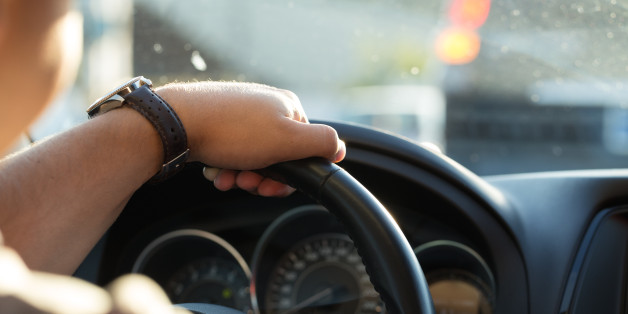 Man behind the wheel in the evening. Young man goes in the car to home after work.