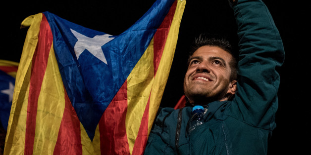 BARCELONA, SPAIN - OCTOBER 01: People wave Catalan flags as they dance and sing after listening to Catalan President Carles Puigdemont speak via a televised press conference as they await the result of the Indepenence Referendum at the Placa de Catalunya on October 1, 2017 in Barcelona, Spain. More than five million eligible Catalan voters are estimated to visit 2,315 polling stations today for Catalonia's referendum on independence from Spain. The Spanish government in Madrid has declared the