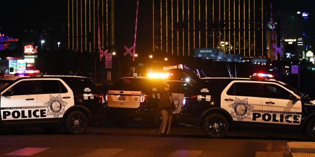 TOPSHOT - Police form a perimeter around the road leading to the Mandalay Hotel (background) after a gunman killed at least 50 people and wounded more than 200 others when he opened fire on a country music concert in Las Vegas, Nevada on October 2, 2017. Police said the gunman, a 64-year-old local resident named as Stephen Paddock, had been killed after a SWAT team responded to reports of multiple gunfire from the 32nd floor of the Mandalay Bay, a hotel-casino next to the concert venue. / AFP PH