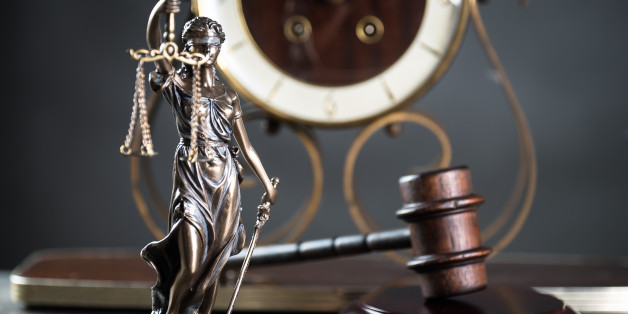 Law and Justice concept. Mallet of the judge, books, scales of justice. Gray stone background, reflections on the floor, place for typography. Courtroom theme.