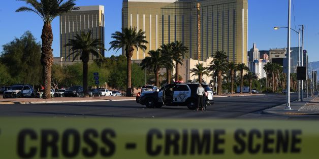 Crime scene tape surrounds the Mandalay Hotel (background) after a gunman killed at least 50 people and wounded more than 200 others when he opened fire on a country music concert in Las Vegas, Nevada on October 2, 2017. Police said the gunman, a 64-year-old local resident named as Stephen Paddock, had been killed after a SWAT team responded to reports of multiple gunfire from the 32nd floor of the Mandalay Bay, a hotel-casino next to the concert venue. / AFP PHOTO / Mark RALSTON (Photo c