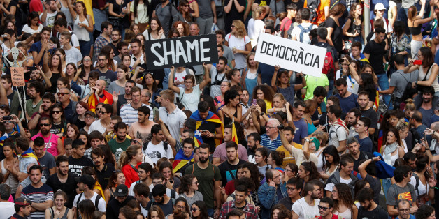 People hold up placards during a demonstration two days after the banned independence referendum in Barcelona, Spain, October 3, 2017. REUTERS/Yves Herman