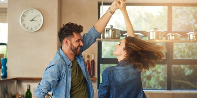 Shot of a happy young couple dancing together at home