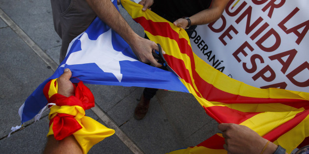 MADRID, SPAIN - OCTOBER 07: Demonstrators cut off the star from a Catalan Pro-Independence flag known as 'Estelada' during a protest against the independence of Catalonia under the slogan 'For the unity of Spain' called by far right wing party Falange Espanola de la Jons at Salvador Dali Square on October 7, 2017 in Madrid, Spain. Tension between the central government and the Catalan region have increased after last weekend's independence referendum. The Spanish government suspended the Catala