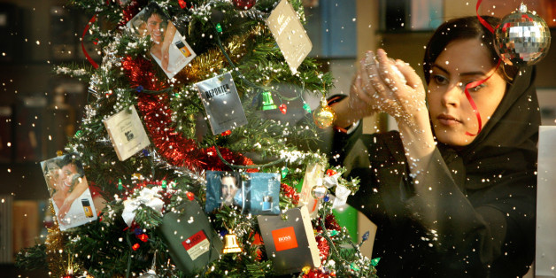 An Iranian woman decorates a store front with Christmas decorations in Tehran December 23, 2003. Christmas, not commonly celebrated in Iran where the majority religion is Islam, is celebrated by the Assyrian and Armenian minorities who are Christians. REUTERS/Morteza Nikoubazl CJF/AA