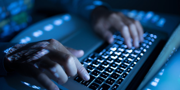 Close-up image of coder typing on computer