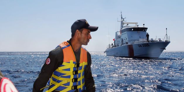 A member of the Tunisian coast guard inspects the maritime borders in the region off Tunisia's northern town of Bizerte during a 24-hour patrol of the area on March 30, 2017.Migrants seeking a better future have long used the Tunisian coast as a launchpad for bids to reach Italy. But in recent years, Tunisian authorities have had to learn to tackle a new form of smuggling -- contraband coming from Europe. / AFP PHOTO / MOHAMED KHALIL / TO GO WITH AFP STORY BY KAOUTHER LARBI (Photo credit
