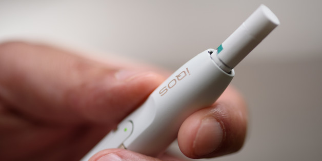 A Philip Morris International Inc. iQOS electronic cigarette is held for a photograph in Tokyo, Japan, on Tuesday, Aug.23, 2016. Philip Morris International and Japan Tobacco Inc. have rolled out products that are heated -- not burned -- in battery-charged devices, seeking to appeal to smokers who want their nicotine fix without the usual smell and smoke. Photographer: Akio Kon/Bloomberg via Getty Images
