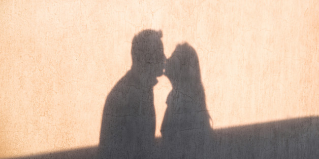 The shadow on the wall of a young loving couple kissing each other and enjoy the tenderness. Happy and loving couple for Valentine's Day.