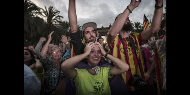 BARCELONA, SPAIN - OCTOBER 10: Pro- independence supporters react as they hear Catalan President Carles Puigdemont announce he will abide by the independence vote as they watch on big screens outside the Parliament of Catalunya as the Catalan President Carles Puigdemont speaks on October 10, 2017 in Barcelona, Spain. After the October 1 referendum and weeks of build up Catalonia's president Carles Puigdemont addressed the Catalan Parliament where he acknowledged that his people voted for indepe