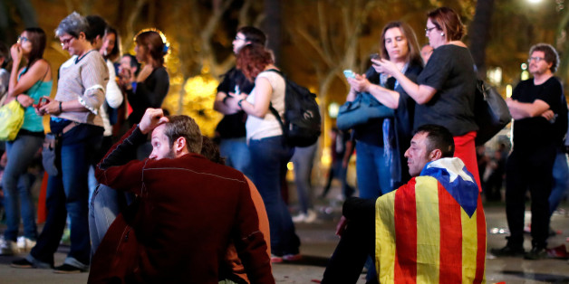People react as they watch a session of the Catalonian regional parliament on a giant screen at a pro-independence rally in Barcelona, Spain, October 10, 2017. REUTERS/Gonzalo Fuentes