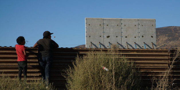 TIJUANA, MEXICO - OCTOBER 5: People watch prototype sections of a border wall between Mexico and the United States under construction on October 5, 2017 in Tijuana, Mexico. Prototypes of the border wall propopsed by President Donald Trump are being built just north of the U.S.- Mexico border, where competitors who are hoping to gain approval to build the wall have until the first of next month to complete their work. (Photo by Sandy Huffaker/Getty Images)