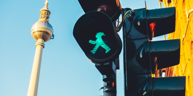 Ein grünes laufendes Männchen signalisiert Bewegung. Ein rotes Ampelmännchen mit ausgestreckten Armen will einen daran hindern.