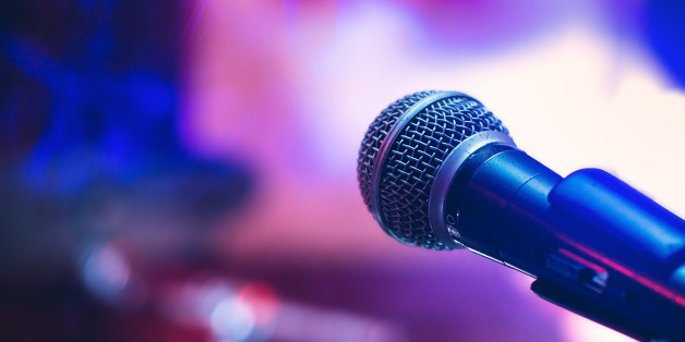 Microphone on the stage on violet background.