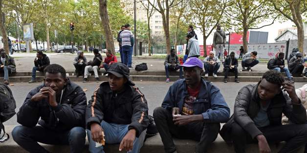 Migrants eat food distributed by the Utopia 56 association in a street of Paris on October 11, 2017.Unprecedented waves of migration are affecting the world today with record numbers of people escaping war-torn regions, poverty, persecution and natural disasters. That influx of people is just a fraction of the record 65.6 million people who were either refugees, asylum seekers or internally displaced around the world by the end of 2016, according to the UN refugee agency. / AFP PHOTO / CHRISTOPH