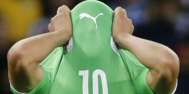 Algeria's Sofiane Feghouli covers his face with his jersey as he reacts to his team's loss at the end of their 2014 World Cup round of 16 game against Germany at the Beira Rio stadium in Porto Alegre June 30, 2014. REUTERS/Edgard Garrido (BRAZIL - Tags: SOCCER SPORT WORLD CUP TPX IMAGES OF THE DAY)