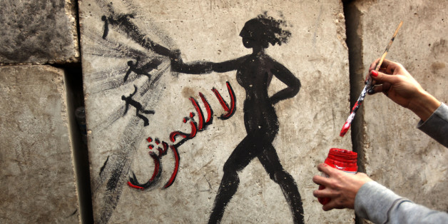 An Egyptian activist draws graffiti depicting a woman and reading in Arabic: 'No to Sexual Harassement' on a wall outside the presidential palace in Cairo on December 14, 2012. Egypt's mainly secular opposition gathered for last-ditch protests against a new constitution it slams as divisive, but on the eve of a referendum it held back from urging a boycott. AFP PHOTO/PATRICK BAZ (Photo credit should read PATRICK BAZ/AFP/Getty Images)