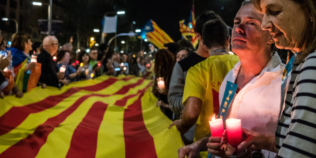 BARCELONA, SPAIN - 2017/10/17: A large flag of Catalonia is seen surrounded by demonstrators holding candle during a protest?Demonstrators took over the streets during the second protest of the day after the admission in prison of Jordi Cuixart and Jordi Sanchez. Around 200,000 people have gathered in Barcelona to ask for the release of the two political prisoners and sovereigntists leaders in prison handed down by judge Carmen Lamela. The demonstrators have the determination to continue with de
