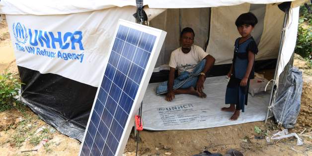 This photo taken on October 7, 2017 shows Rohingya refugees waiting for a solar lantern to charge at the Kutupalong refugee camp in Cox's Bazar.
The squalid camps in Bangladesh that are now home to nearly 600,000 newly arrived Rohingya have no running water and barely any toilets, but they do have power -- thanks to a proliferation of solar panels. that means refugees can charge their phones and power electric lights and fans -- a lifeline in tents that become bakingly hot in the strong sun.
/ AFP PHOTO / INDRANIL MUKHERJEE / TO GO WITH AFP STORY BANGLADESH-MYANMAR-REFUGEE-UNREST-ENERGY,FOCUS BY ALEXANDRE MARCHAND (Photo credit should read INDRANIL MUKHERJEE/AFP/Getty Images)