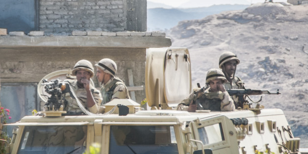 Aswan, Egypt - March 5, 2015: Four soldiers, flagging badly, try not to let the heat and the boredom overcome them at a checkpoint near Aswan.