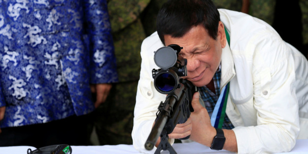 Philippine President Rodrigo Duterte checks the scope of a 7.62mm sniper rifle during the turnover ceremony of China's urgent military assistance given "gratis" to the Philippines, at Clark Air Base, near Angeles City, Philippines June 28, 2017. REUTERS/Romeo Ranoco TPX IMAGES OF THE DAY