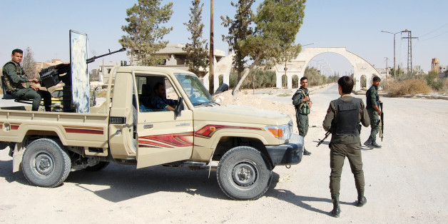 Syrian soldiers and pro-regime militiamen gather in the recently retaken desert town of Al-Qaryatain on October 22, 2017.Al-Qaryatain was a symbol of religious coexistence before the civil war broke out in 2011, with some 900 Christians among its population of 30,000. / AFP PHOTO / STRINGER (Photo credit should read STRINGER/AFP/Getty Images)