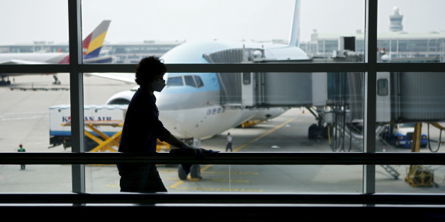 An employee wearing a mask to prevent contracting Middle East Respiratory Syndrome (MERS) wipes a travelator at Incheon International Airport in Incheon, South Korea, June 14, 2015. A South Korean hospital suspended most services on Sunday after being identified as the epicentre of the spread of the deadly respiratory disease that has killed 15 people since being diagnosed in the country nearly four weeks ago. REUTERS/Kim Hong-Ji