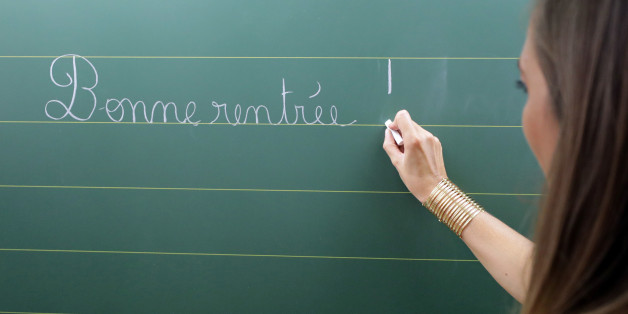 A teacher writes the phrase "all the best for going back to school" on the blackboard of her classroom on the first day of the new school year at a primary school in Nice, France, September 4, 2017. REUTERS/Eric Gaillard