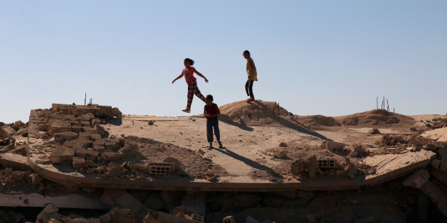 Syrian children are seen playing on a damaged house in Bosra al Sham town, south of Deraa, Syria October 1, 2017. REUTERS/Alaa al Faqir