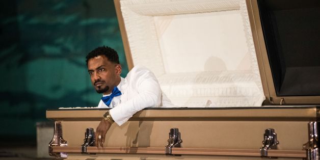 Ethiopian film director Zekarias Mesfin surprises audience by appearing from inside a coffin on the stage of the National Theatre of Ethiopia, during the premiere of his film 'Ewir Amora Kelabi', in Addis Ababa, on October 16, 2017.Zekarias Mesfin spent months making a movie depicting his perilous illegal migration from Ethiopia, but at the film's premiere this week, he arrived in a coffin carried by six white-gloved pallbearers. / AFP PHOTO / Zacharias ABUBEKER (Photo credit should read