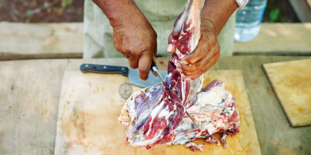 The man cuts meat of a ram for pilaf. Selective focusing