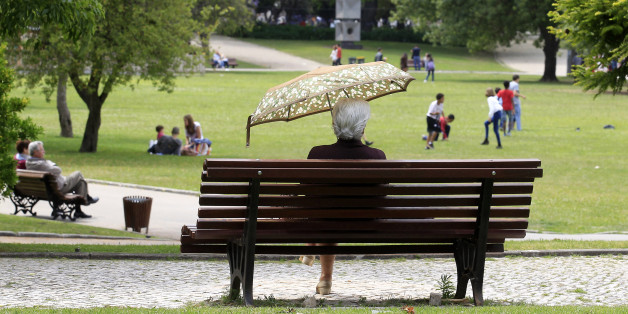 A woman shields herself from the sun with an umbrella at a park in Lisbon June 10, 2013. REUTERS/Jose Manuel Ribeiro (PORTUGAL - Tags: SOCIETY)